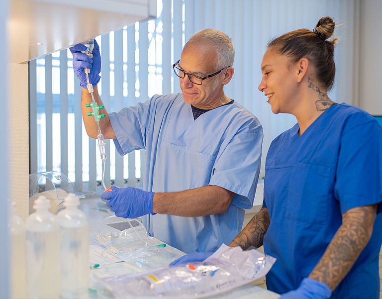 Das Bild zeigt Pflegefachkräfte der Medizinischen Klinik III die eine Infusion richten.