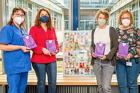 Das Bild zeigt Kerstin Klein, Antje Rinaldi, Ines Dombrowski, Petra Schlömer (Stationsleitung S25) und Janina Schmidt mit Kind bei der Geschenkeübergabe (v.l.n.r.)