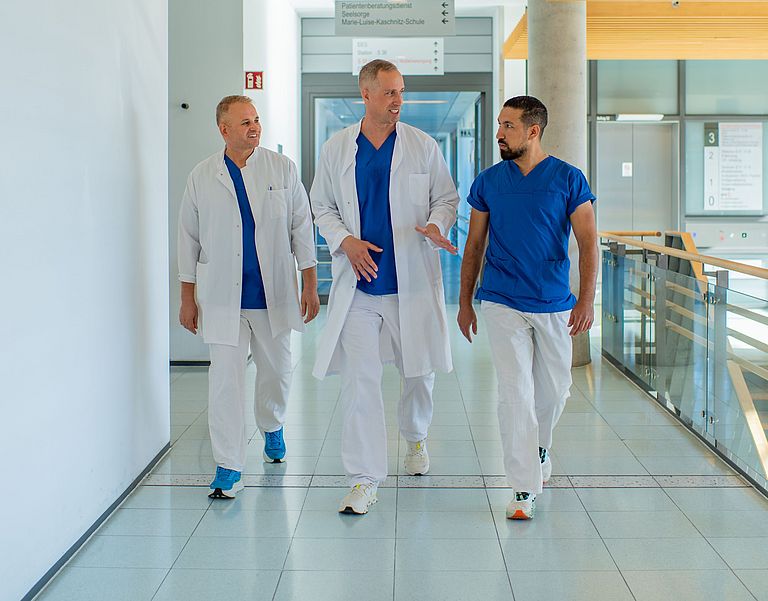 Ein Ärzteteam um Prof. Johannes Schultz läuft einen Gang entlang.