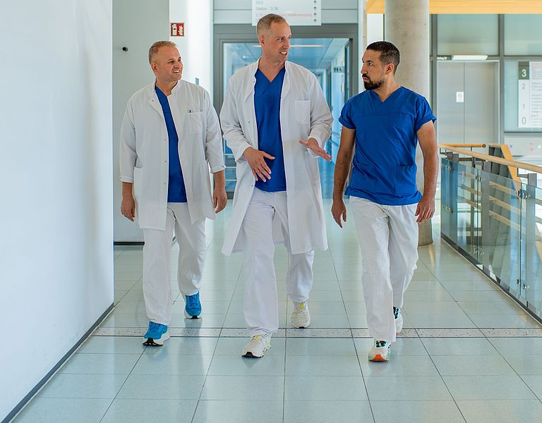 Ein Ärzteteam um Prof. Johannes Schultz läuft einen Gang entlang.