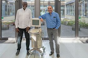 Das Bild zeigt Yusupha Kuyateh und Volker Mayer mit dem Sonografiegerät.