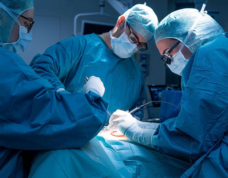 Das Bild zeigt drei Operateure bei einer Schilddrüsen-OP.
