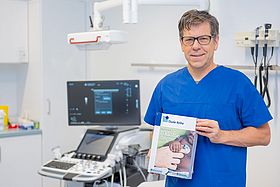 Prof. Sascha Meyer hält die Neuauflage des Lehrbuches in den Händen.