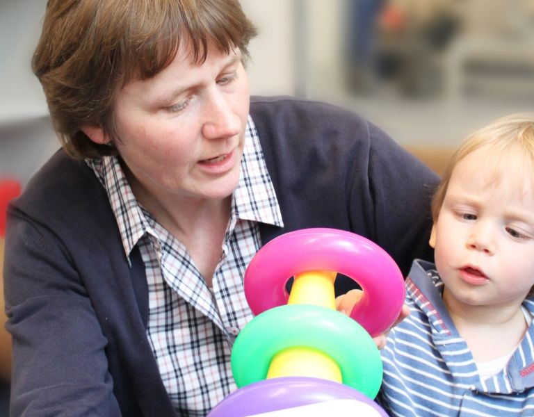 Das Bild zeigt eine Frau und ein Kleinkind beim Spielen