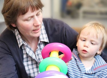 Das Bild zeigt eine Frau und ein Kleinkind beim Spielen