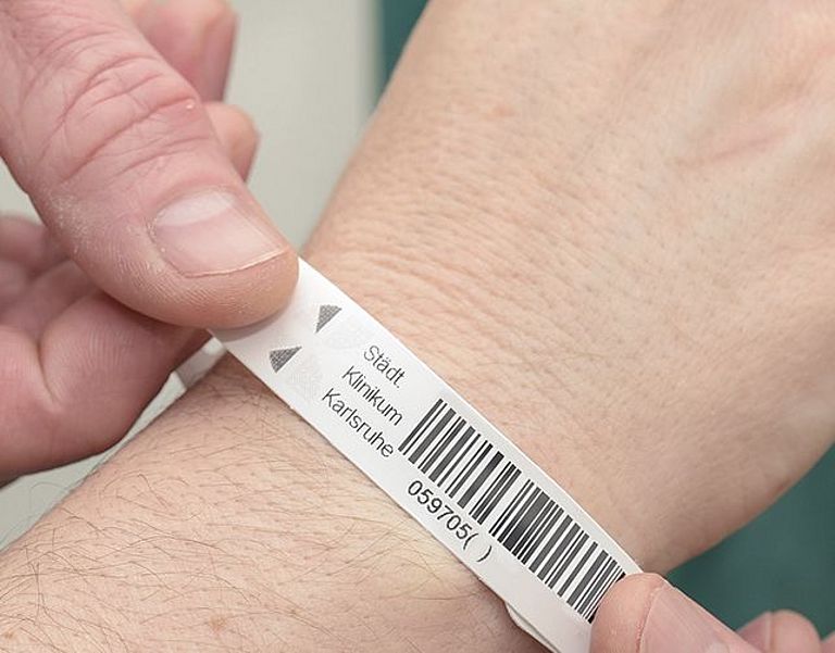 Das Bild zeigt das Anlegen eines Patientenarmbandes 