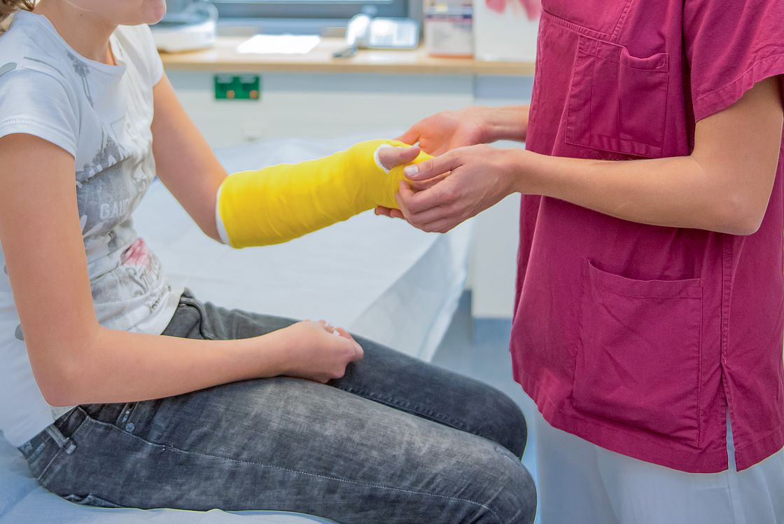 Das Foto zeigt ein Kind, dessen Arm eingegipst wird.