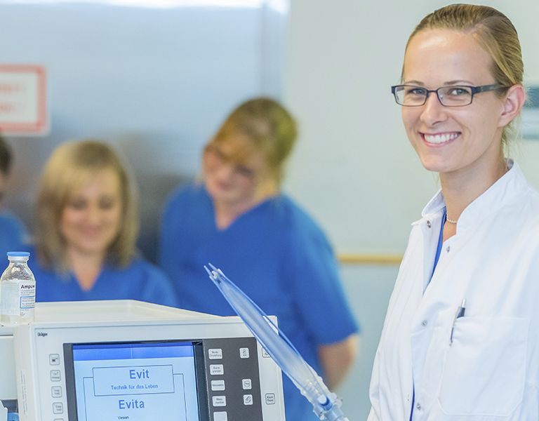 Das Bild zeigt eine Ärztin und 4 Gesundheits- und Krankenpflegerinnen