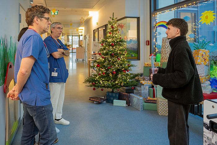 Noel Goda übergibt die Geschenke an die Prof. Sascha Meyer und Dr. Alfred Leipold.