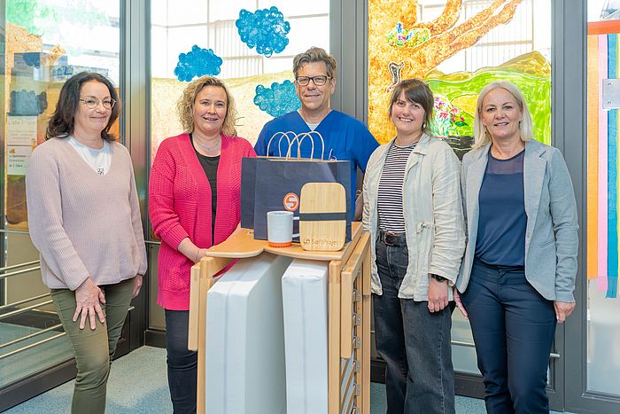 Das Bild zeigt von links: Kordula Hohaus, Yvonne Haßler, Prof. Sascha Meyer, Linda Gierich und Tanja Selter mit einer neu angeschafften Elternliege. 