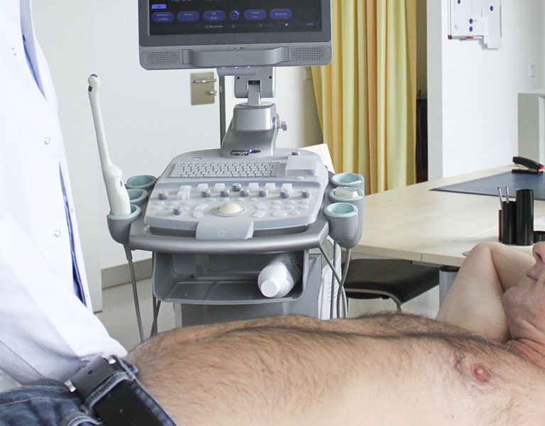 Das Bild zeigt den Einsatz eines Ultraschallgeräts am Patienten