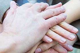 Das Bild zeigt übereinandergelegte Hände