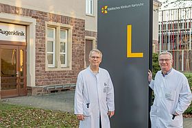 Das Bild zeigt Dr. Heink de Groot (li.) und Dr. Andreas Buchholz vor der Augenklinik.