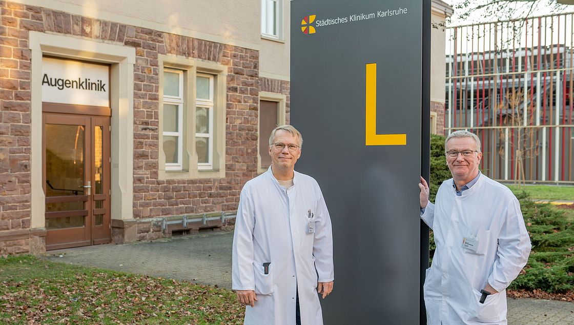 Das Bild zeigt Dr. Heink de Groot (li.) und Dr. Andreas Buchholz vor der Augenklinik.