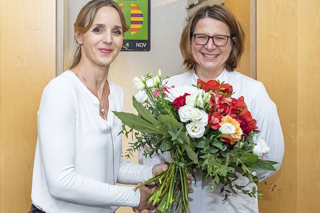 Saskia Morakis, Geschäftsführerin am Medizinischen Versorgungszentrum am Städtischen Klinikum Karlsruhe, überreicht Dr. Katharina Ruppender anlässlich der Praxiseröffnung einen Blumenstrauß.