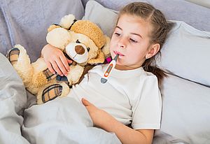 Mädchen im Bett mit Thermometer