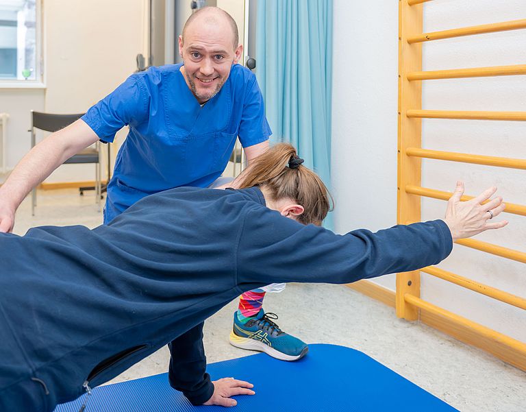 Das Bild zeigt einen Physiotherapeuten und eine Patientin.