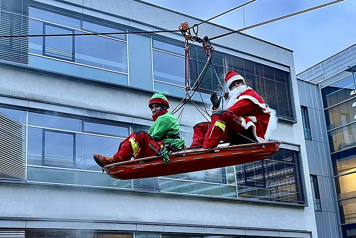 Das Bild zeigt verkleidete Höhenretter, die sich abseilen.