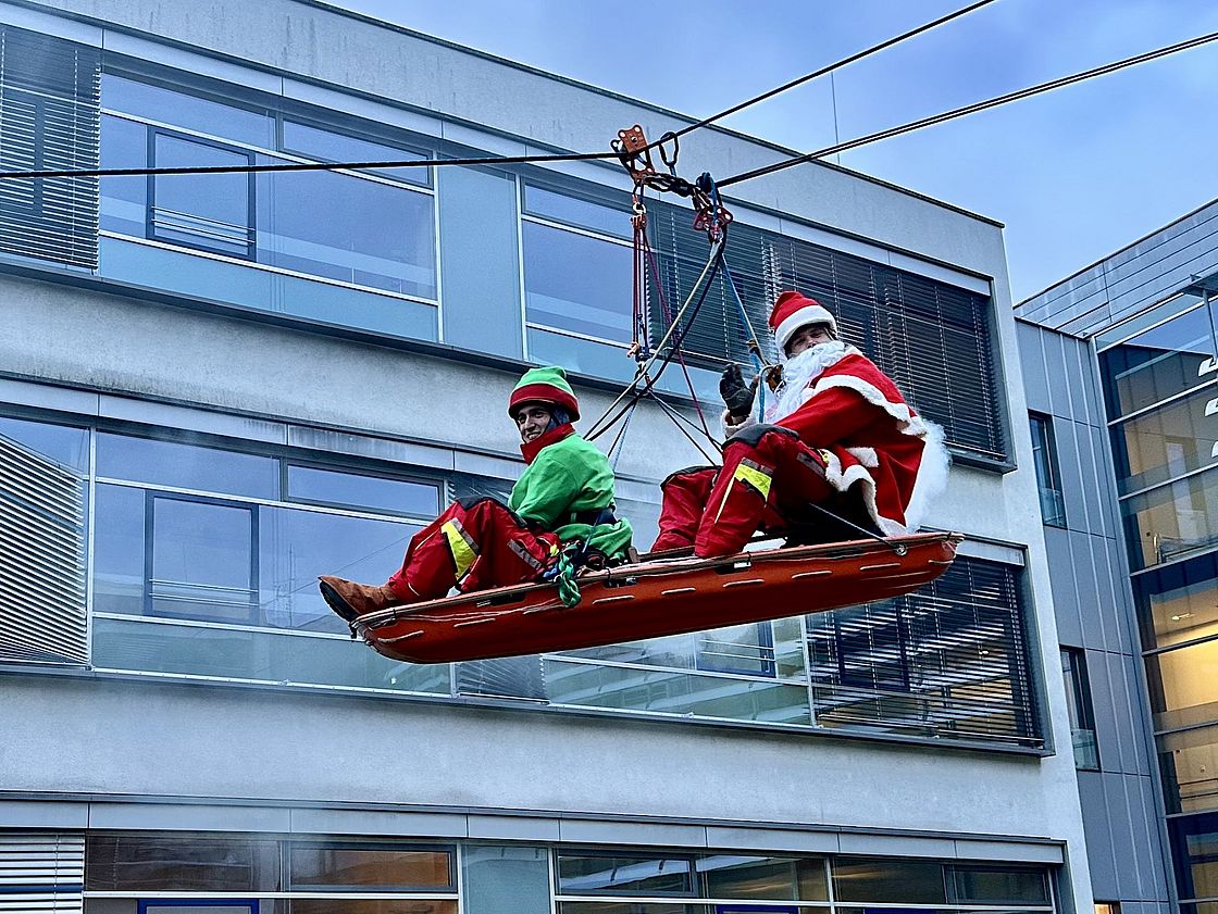Das Bild zeigt verkleidete Höhenretter, die sich abseilen.