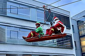 Das Bild zeigt verkleidete Höhenretter, die sich abseilen.