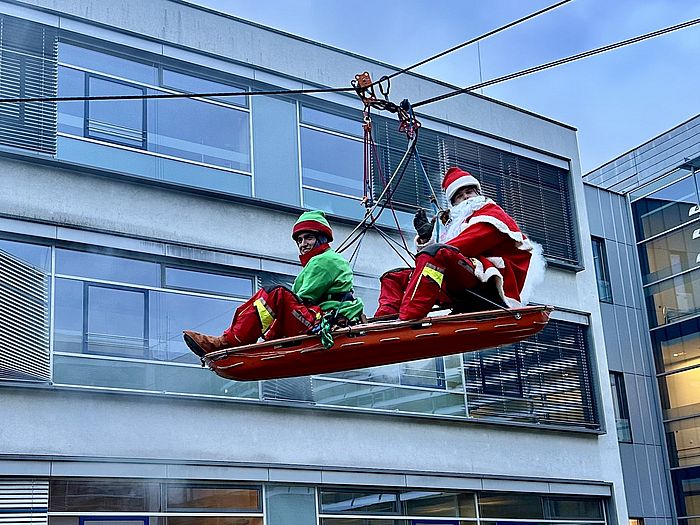 Das Bild zeigt verkleidete Höhenretter, die sich abseilen.