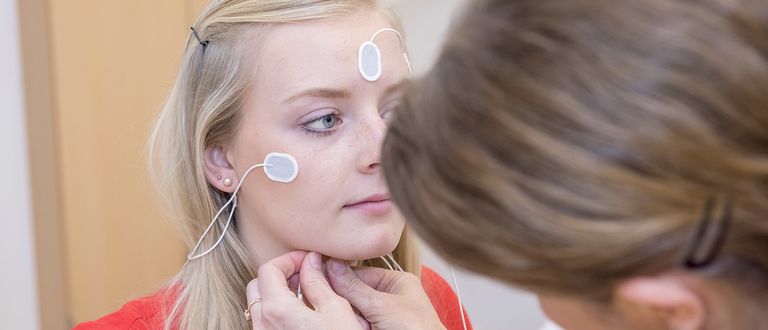 Das Bild zeigt die Verkabelung einer Patienten mit Elektroden am Kopf und-Stirnbereich