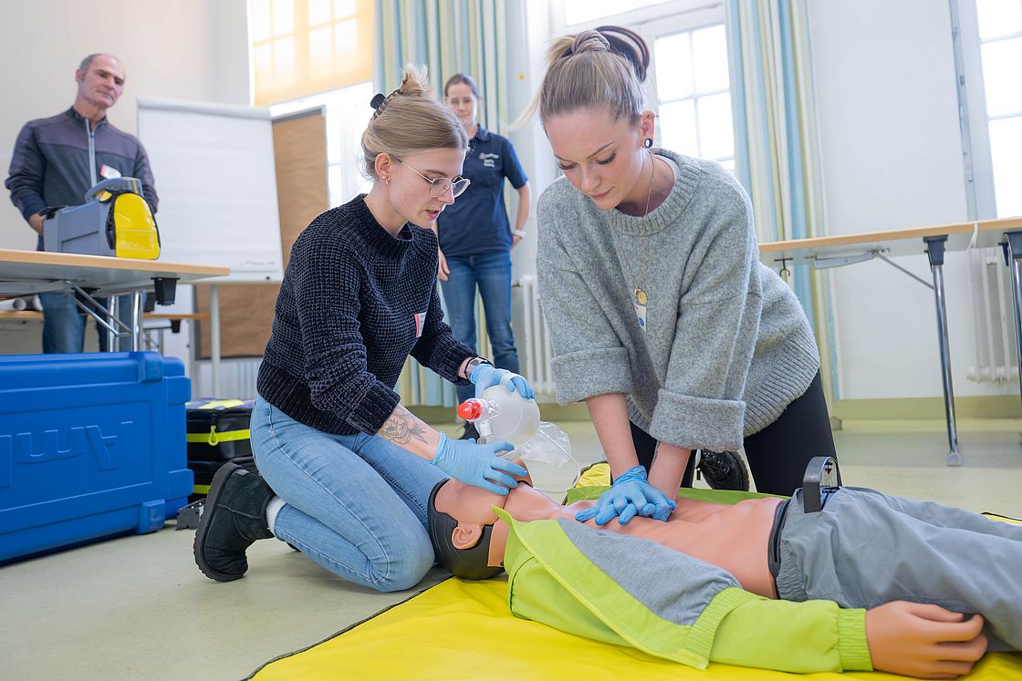 Das Bild zeigt zwei Kursteilnehmende beim Üben der Reanimation.