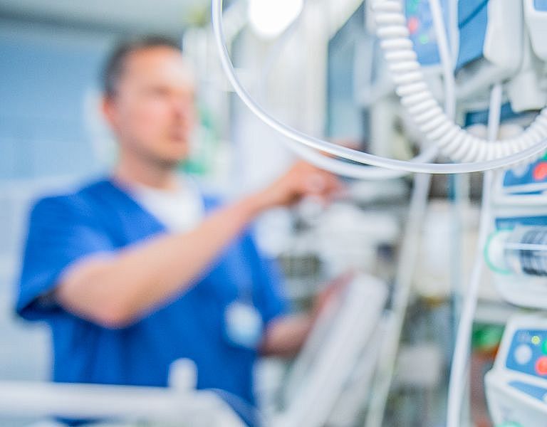 Das Bild zeigt ein Intensiv Fachkranken Pfleger beim bedienen der Medizinischen Gerätschaften 