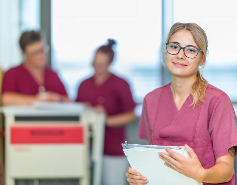 Das Bild zeigt eine Gesundheits- und Krankenpflegerin mit Patientenakte