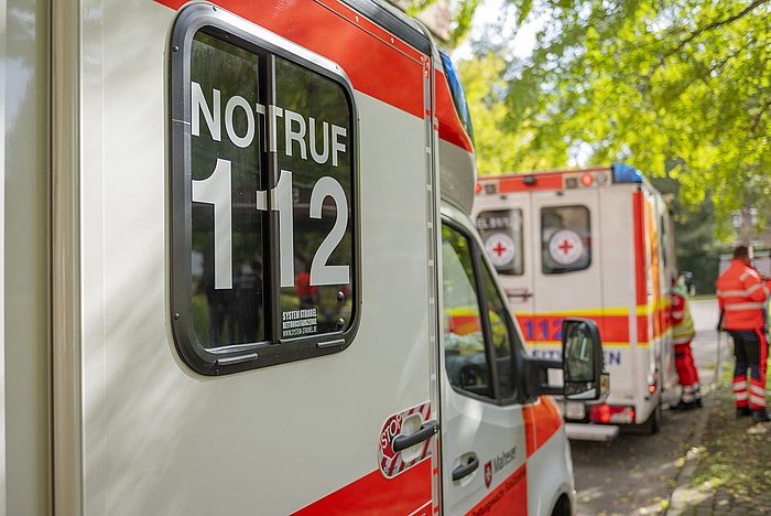 Der Bildausschnitt zeigt einen Teil eines Rettungswagens. Gut zu erkennen ist der Aufdruck "Notruf 112".