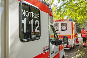 Der Bildausschnitt zeigt einen Teil eines Rettungswagens. Gut zu erkennen ist der Aufdruck "Notruf 112".