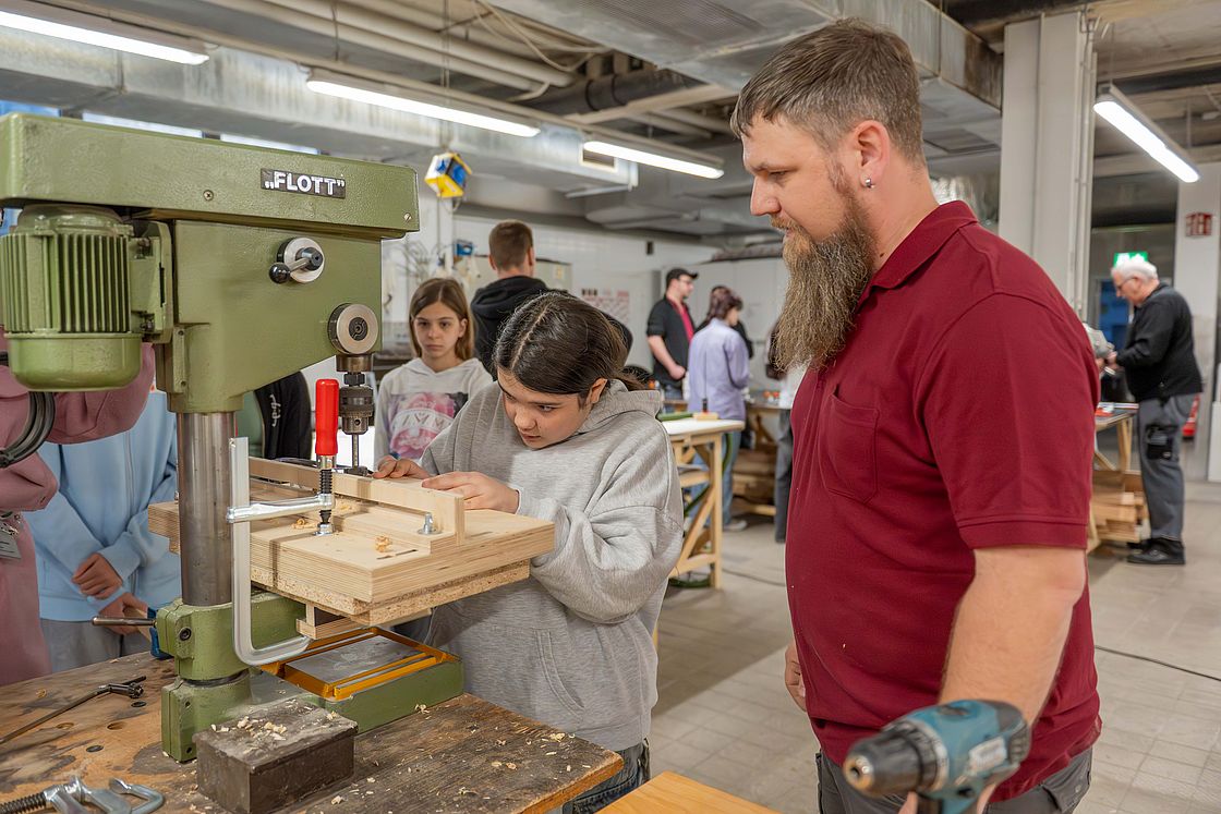 Das Bild zeigt ein Mädchen an der Werkbank in der Werkstätte des Klinikums.