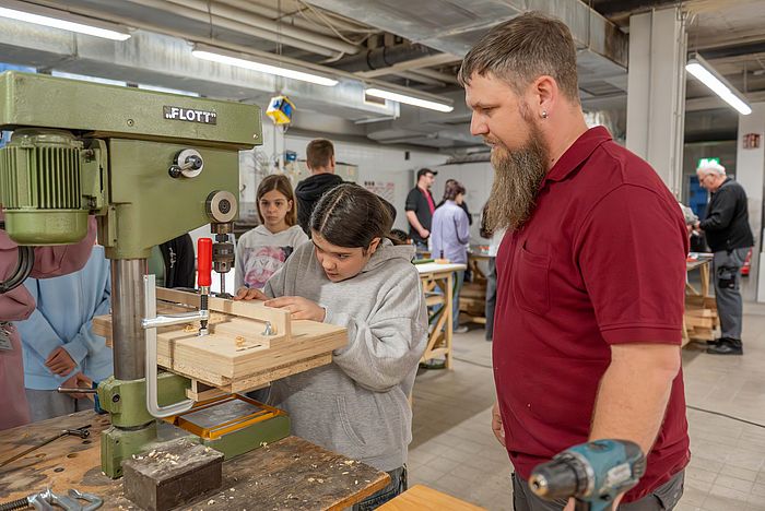 Das Bild zeigt ein Mädchen an der Werkbank in der Werkstätte des Klinikums.