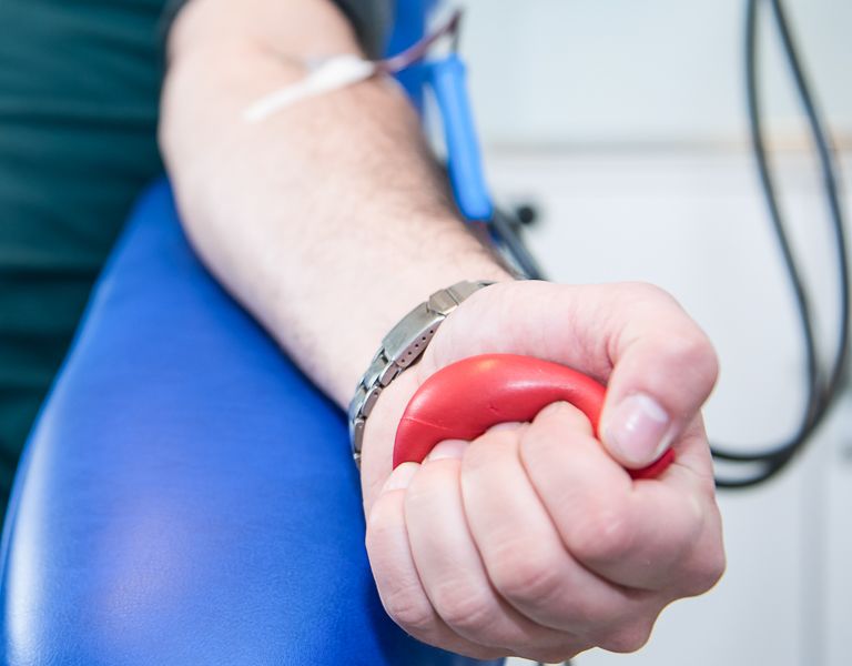 Das Bild zeigt eine Person mit ausgestrecktem Arm bei der Blutspende.