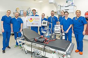 Das Bild zeigt Prof. Dr. Julian Widder (3.v.l.) und Dr. Jonas Neuser (4.v.l.) mit Kolleginnen und Kollegen aus der zentralen Notaufnahme, von der Intensivstation M0E und aus dem Herzkatheterlabor.