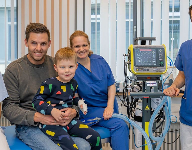 Das Team der Sedation Unit mit einem Patienten und seinem Vater. 