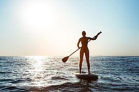 Eine Frau auf einem Stand-Up-Paddle.