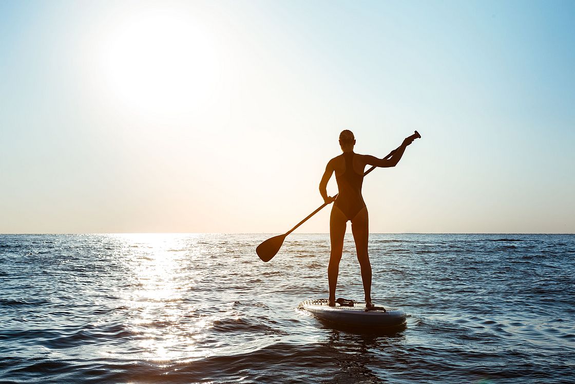 Eine Frau auf einem Stand-Up-Paddle.