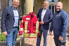 Die Geschäftsführer Prof. Dr. Michael  Geißler und Markus Heming übergeben die Einsatzkleidung an Dr. Björn Bergau