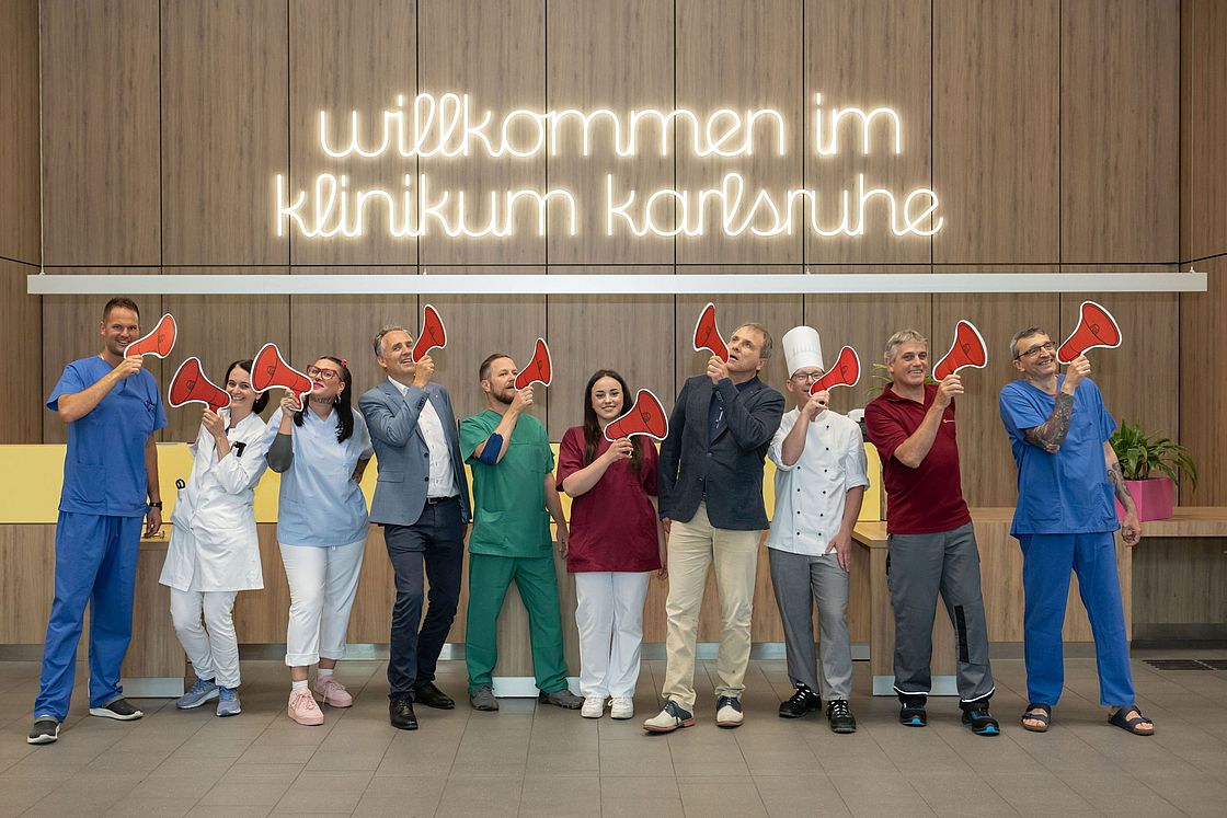 Das Bild zeigt verschiedene Berufsgruppen mit Megafonen