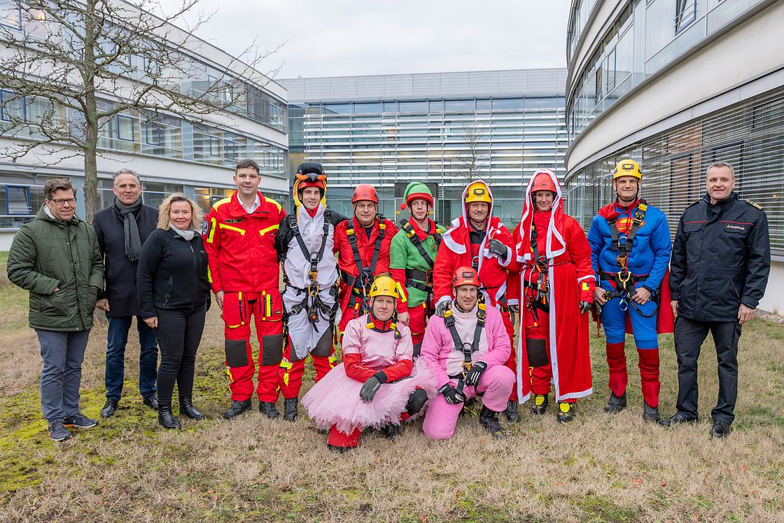 Das Bild zeigt ein Gruppenbild der verkleideten Feuerwehrleute anlässlich der Nikolausaktion an der Kinderkliinik