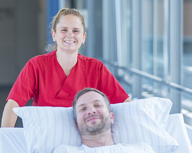 Das Bild zeigt den Patientenbegleitservice bei der Verlegung eines Patienten