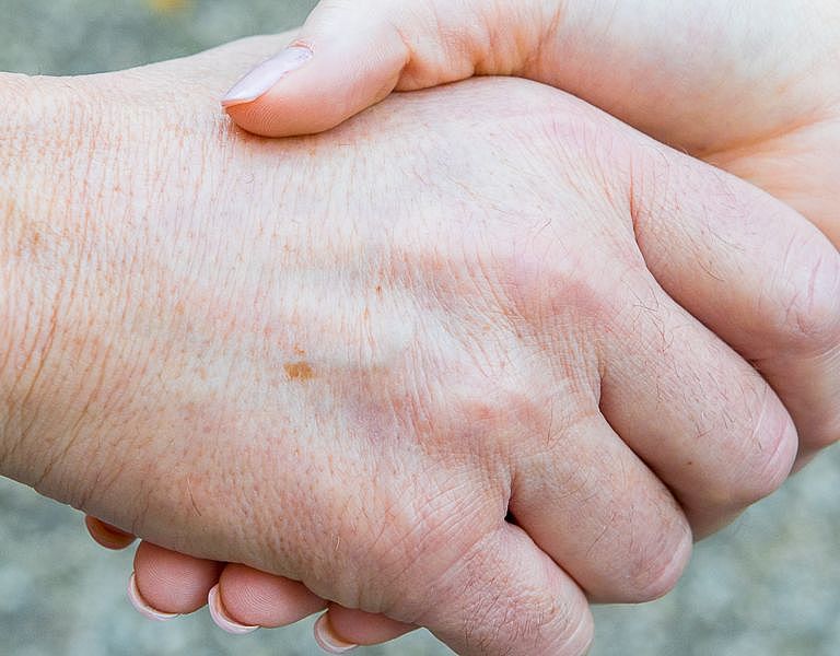 Das Bild zeigt zwei sich reichende Hände.