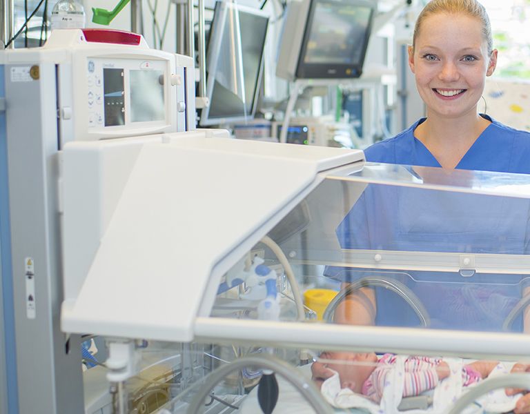 Das Bild zeigt eine Gesundheits- und Krankenpflegerin der Neugeborenenstation