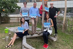 Das Bild zeigt mehrere Personen um Autor Michael Wollhöwer bei der Buchvorstellung