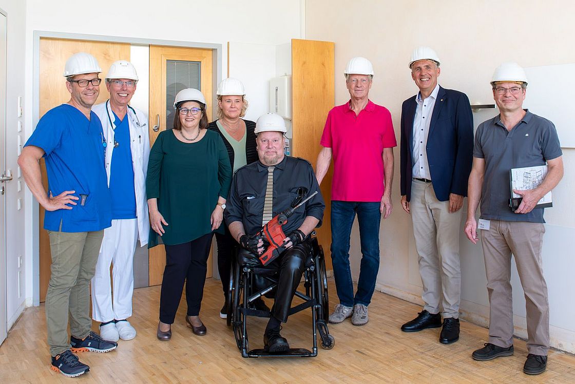 Das Bild zeigt Prof. Sascha Meyer, Alfred Leipold, Oberarzt auf der Station S24, Admira Knoll, Yvonne Haßler, Pflegedienstleitung im Zentrum für Kinder und Frauen, Andreas „Joker“ Jopp, Peter Knoll, Vorsitzender der FUoKK Stiftung, Markus Heming und Dipl.-Ing. Stefan Eller (v.l.n.r.) auf der S24, wo bereits das erste Gerät eingebaut wurde.
