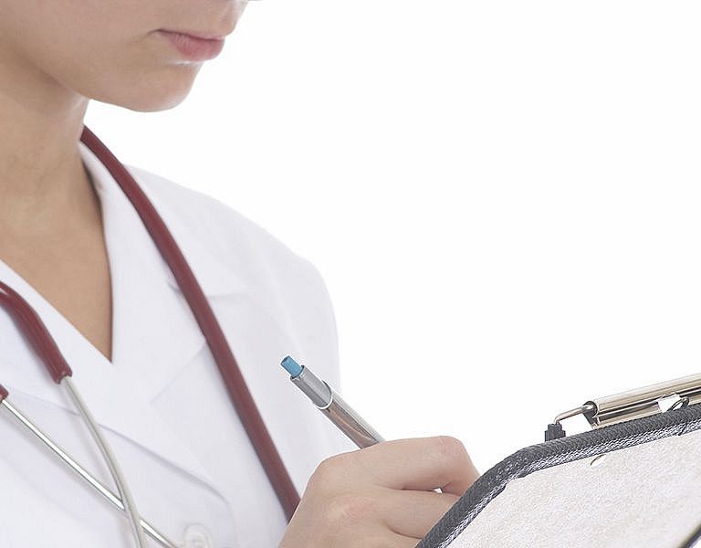 Das Bild zeigt eine Ärztin mit Klemmbrett und Stetoskop um den Hals.