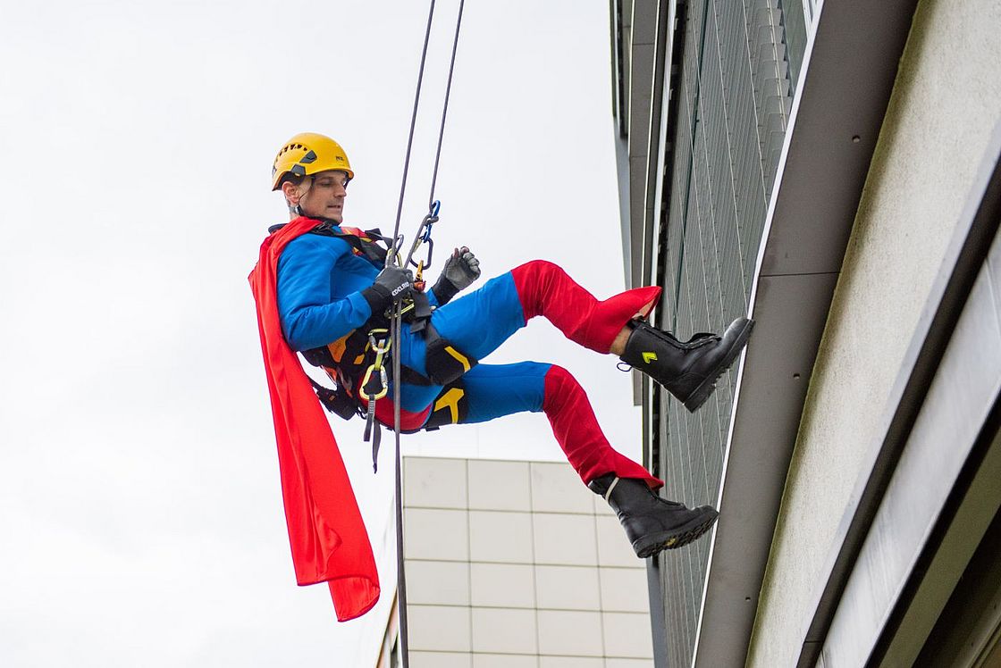 Das Bild zeigt einen als Superman verkleideten Höhenretter