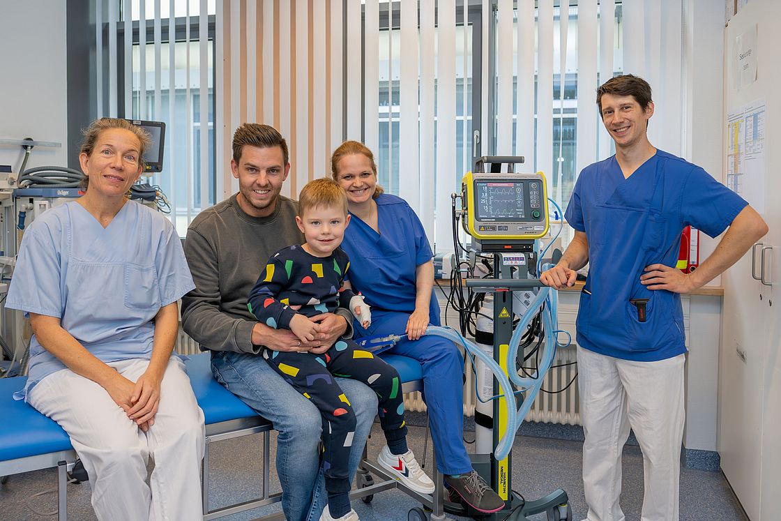 Das Bild zeigt einen Teil des Sandmännchen-Teams mit einem Patienten und seinem Vater.