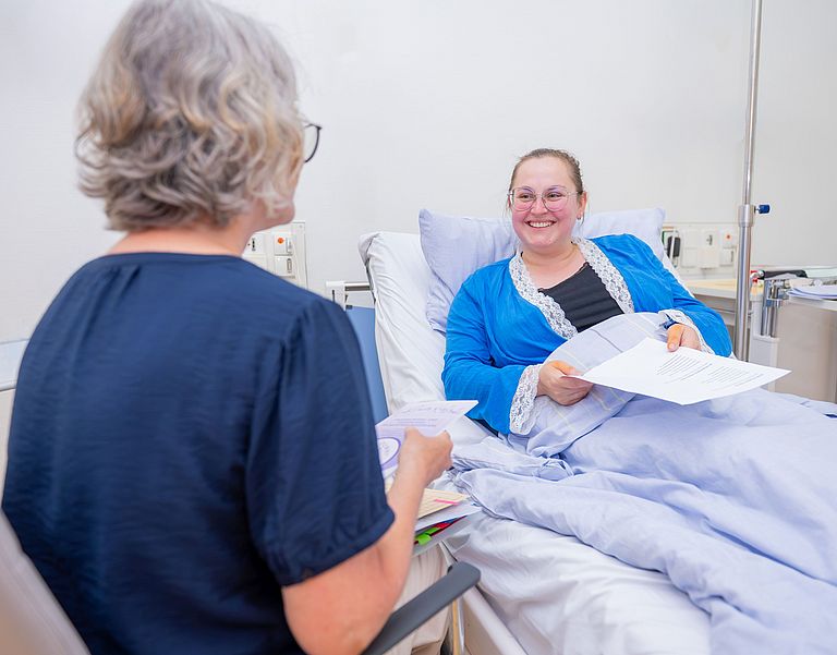 das Bild zeigt ein Beratungsgespräch im Patientenzimmer.